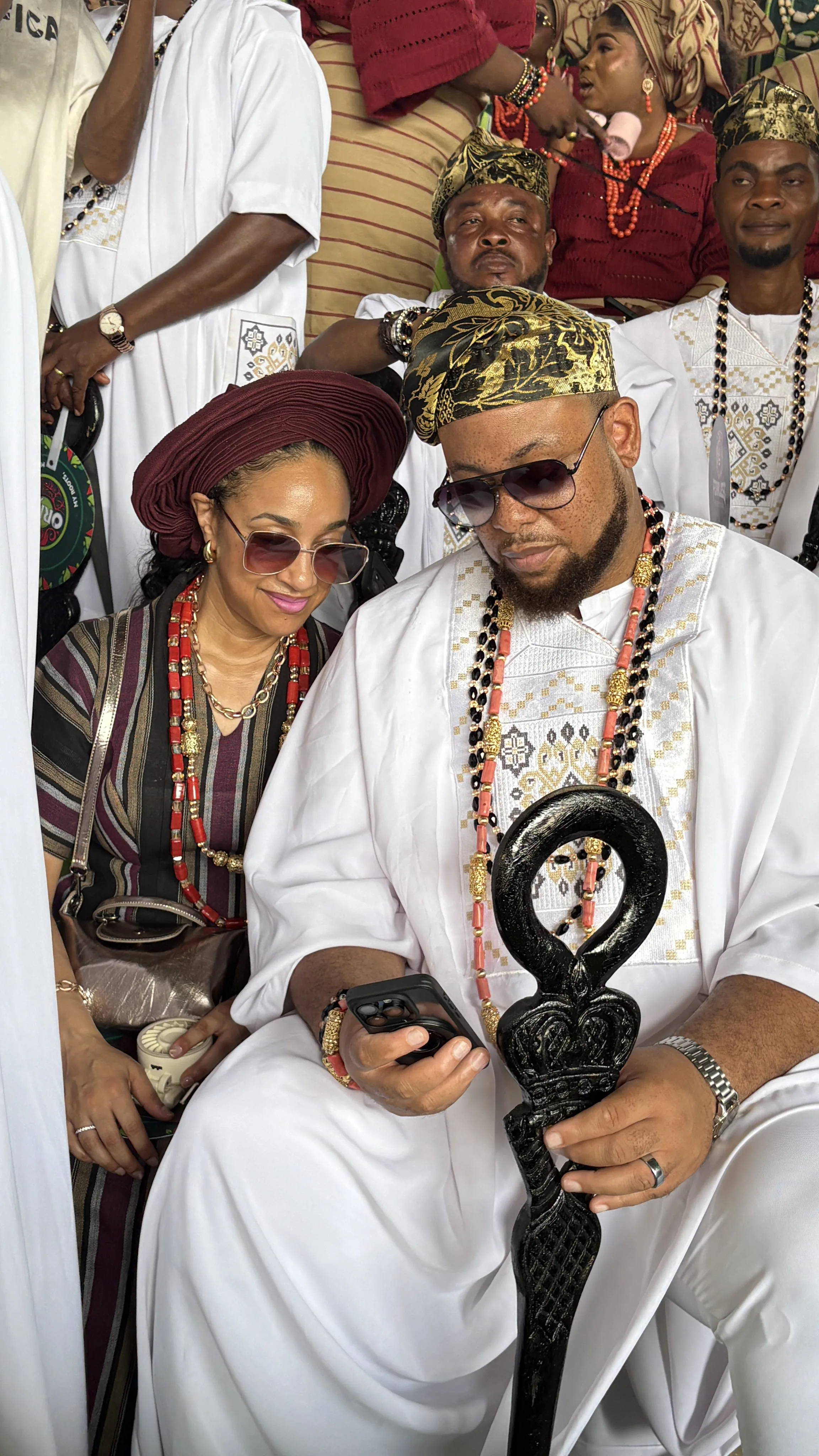Man in white agbada holding a black ceremonial walking stick at Ojude Oba 2026